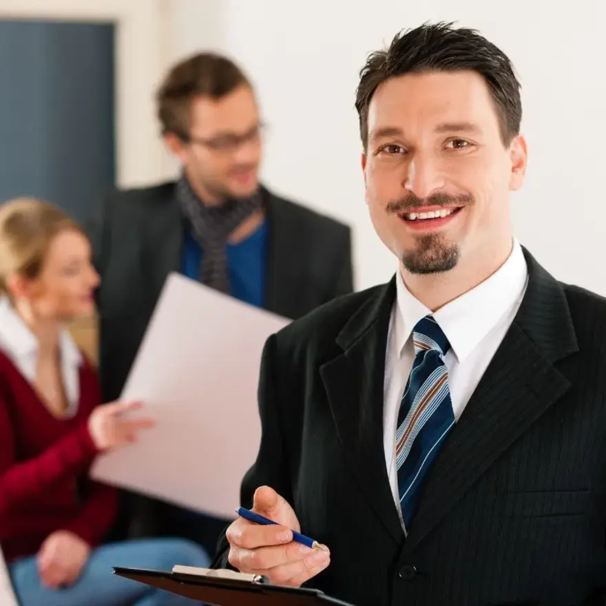 Un homme en costume et cravate tenant un clipboard.