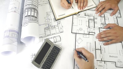 Équipe de conception architecturale collaborant sur des plans architecturaux dans un bureau moderne