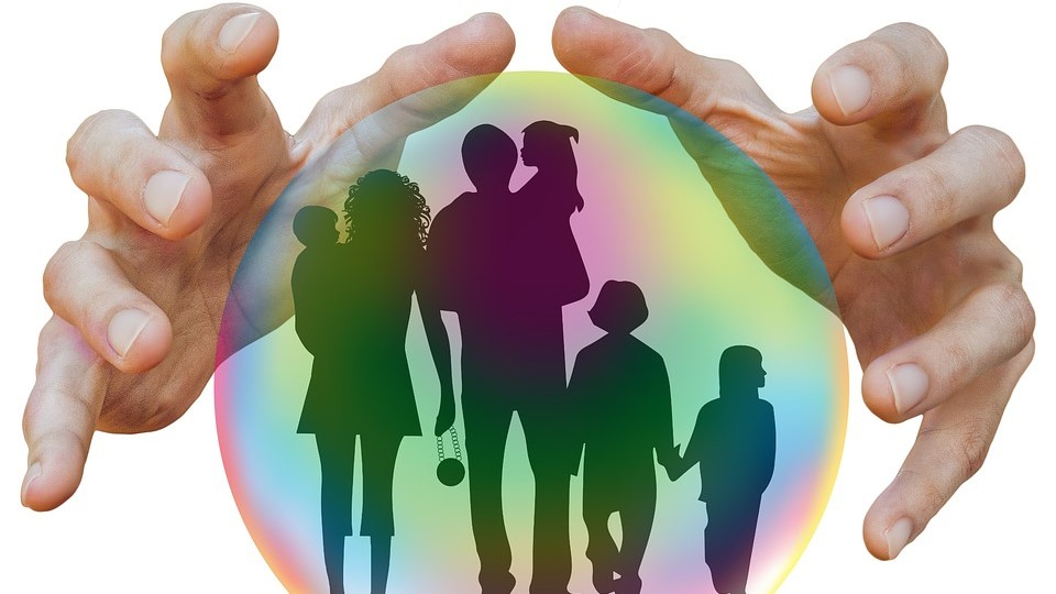 Une famille est silhouettée à l'intérieur d'une sphère colorée en arc-en-ciel