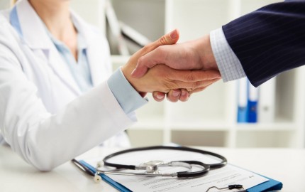 Un médecin serre la main d'un patient, symbolisant une interaction professionnelle et bienveillante