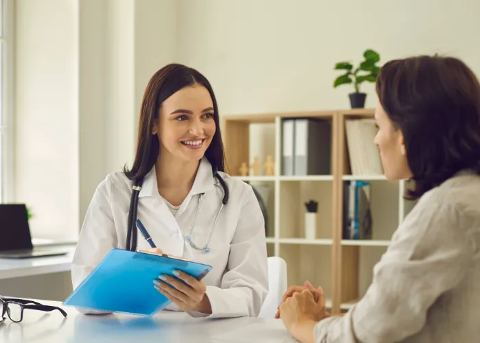 Une femme s'entretient avec un médecin dans un cabinet médical, abordant des questions de santé