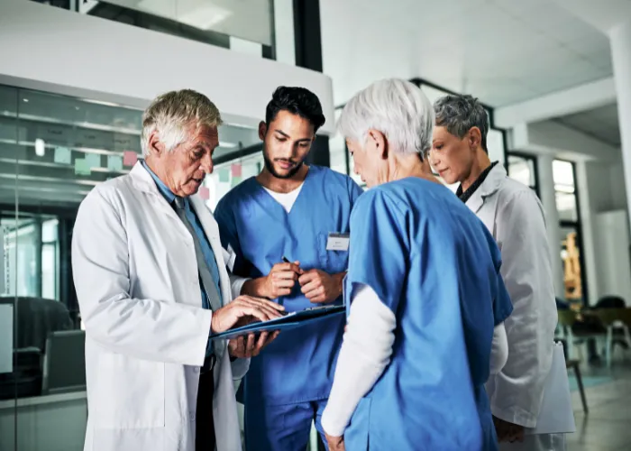 Équipe médicale en discussion autour d'une tablette
