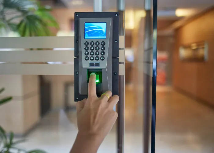 Une personne utilise un lecteur d'empreintes digitales pour déverrouiller une porte