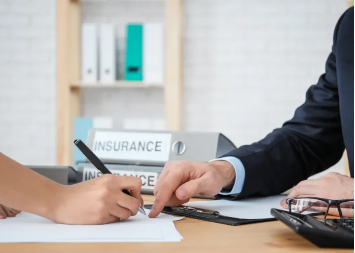 Un agent d'assurance et un client signent un contrat ensemble dans un environnement de travail