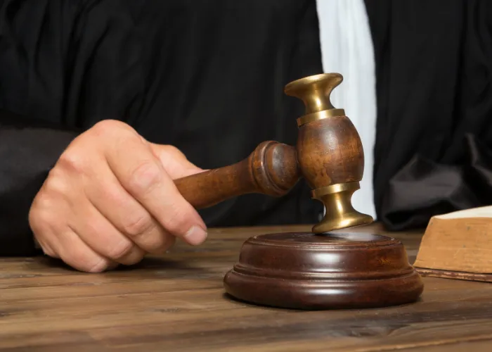 Un maillet de juge posé sur une table en bois, symbolisant l'autorité et la justice dans un cadre judiciaire