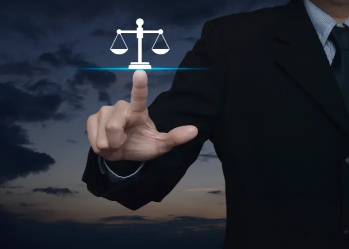 Un homme d'affaires tenant une balance de la justice sur un écran tactile, symbolisant l'équilibre et l'équité dans les affaires